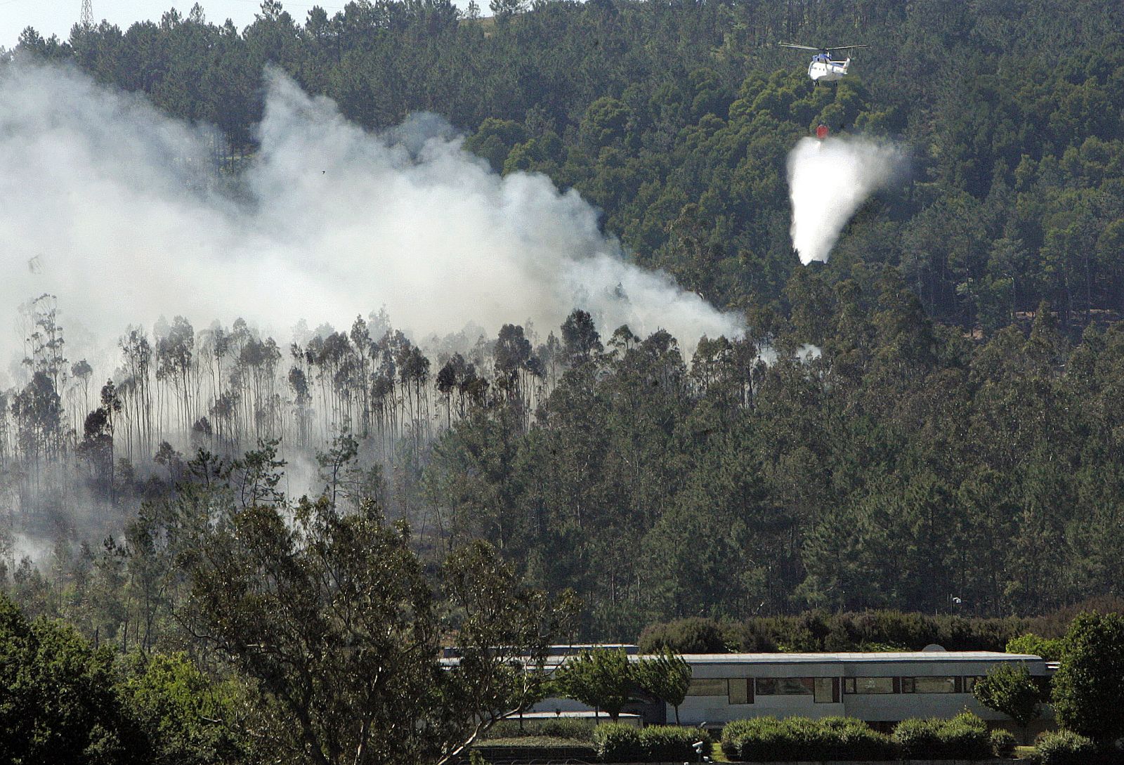DOS HELICÓPTEROS Y OTROS MEDIOS TRATAN DE EXTINGUIR UN INCENDIO EN EL PEDROSO