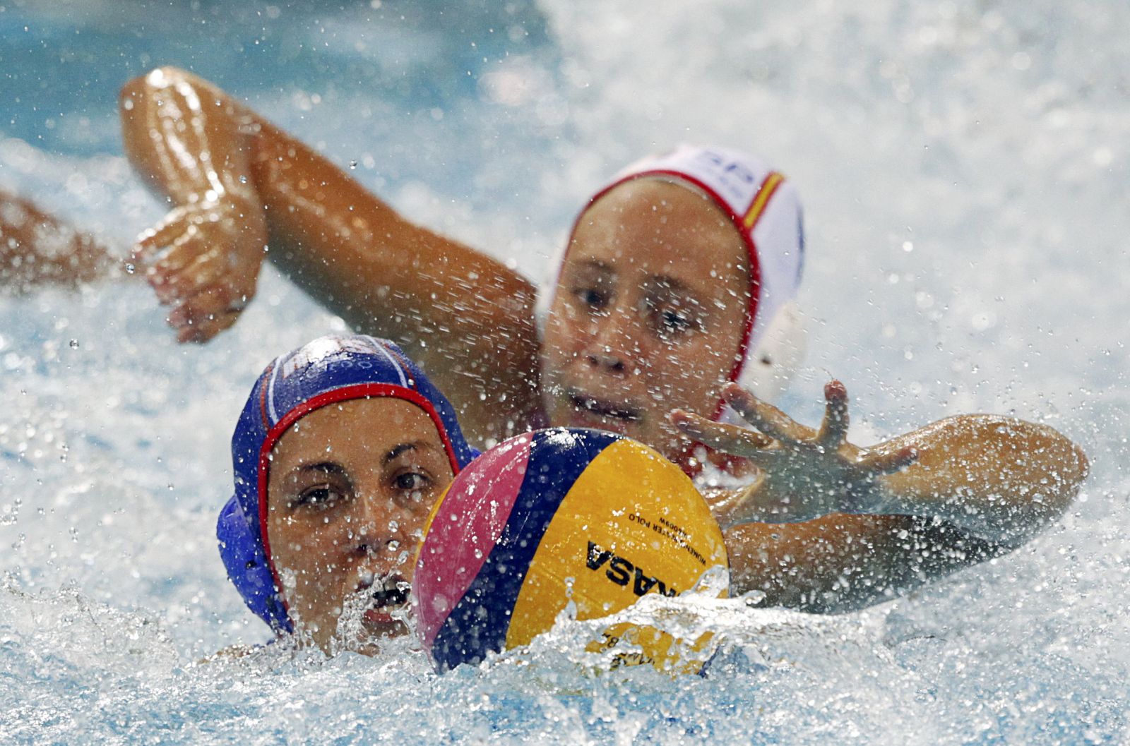 Russia's Antonova clears ball in front of Spain's Meseguer Flaque during their preliminary round women's water polo match at 14th FINA World Championships in Shanghai