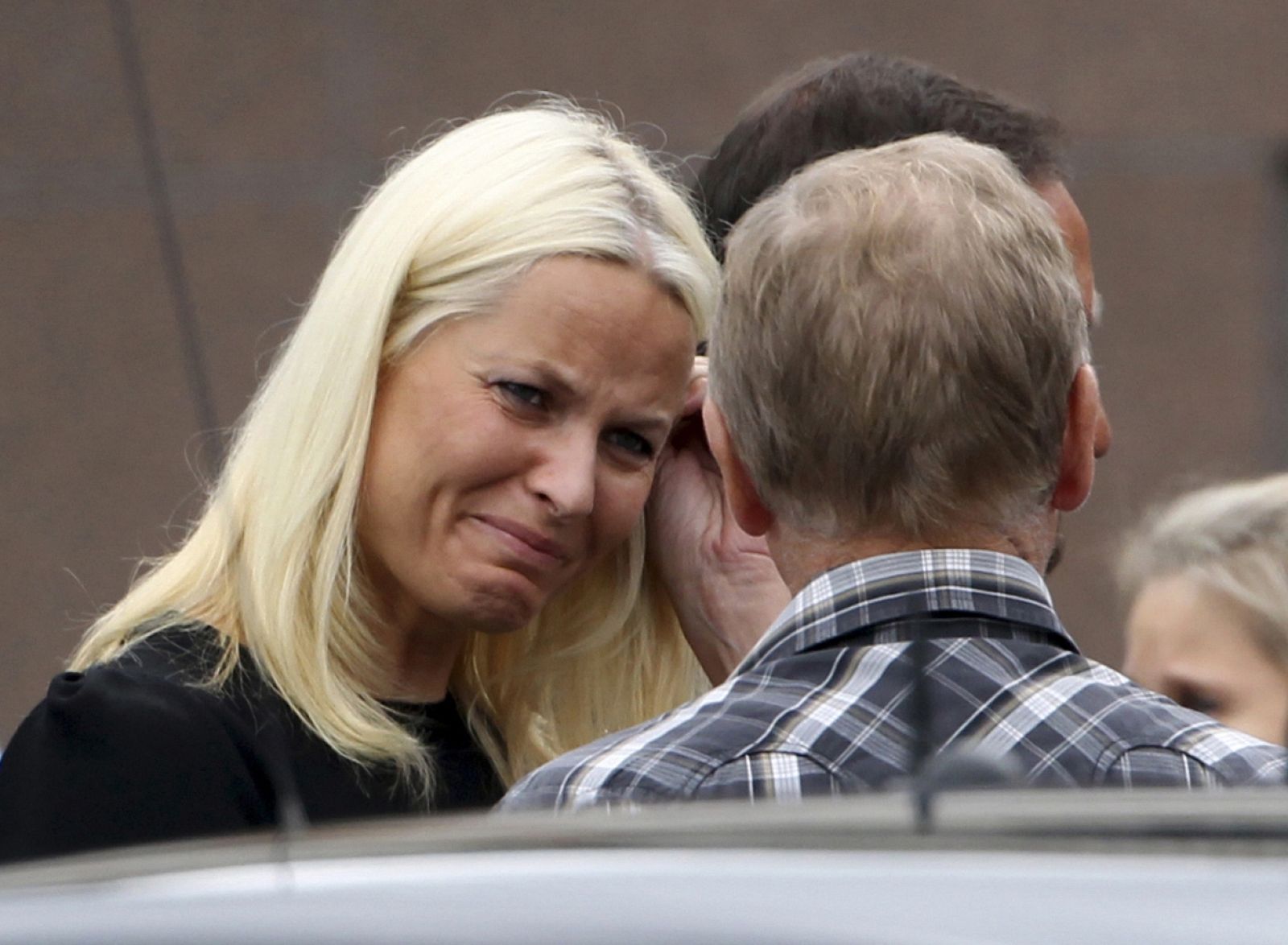 La princesa noruega Mette Marit llora mientras habla con un familiar de las víctimas tras el funeral oficiado el domingo.