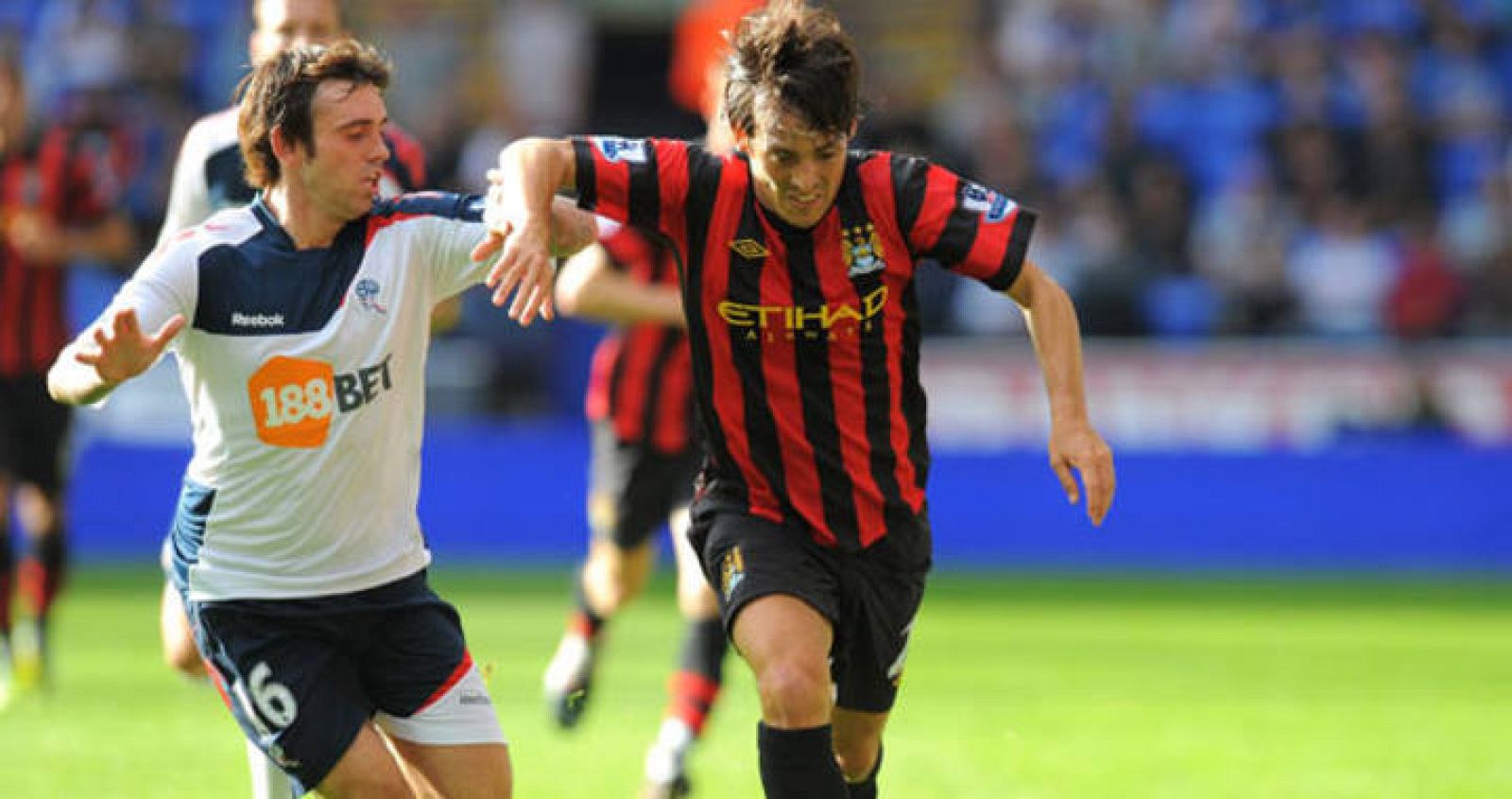 El jugador del Bolton, Mark Davies intenta parar al español del Manchester City, David Silva.