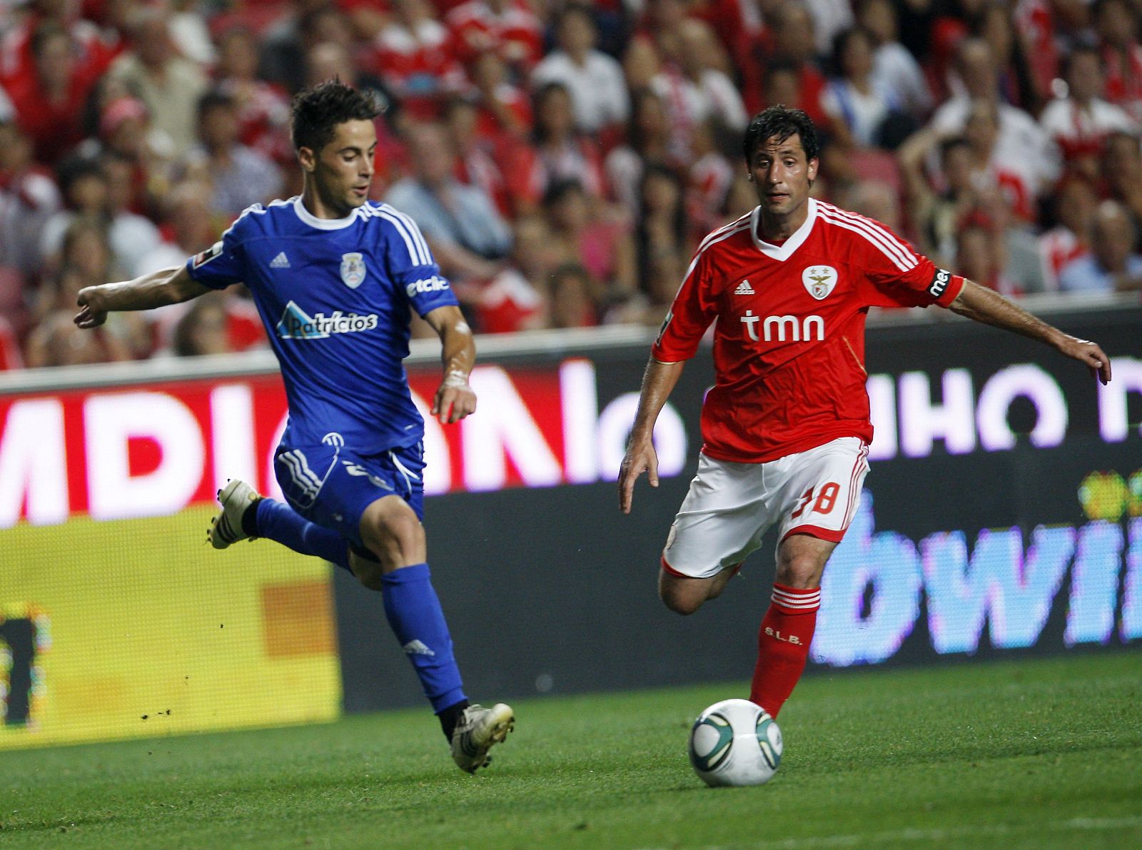 Benfica's Juan Capdevila fights for the ball with CD Feirense's Diogo Rosado during their Portuguese Premier League soccer match at Luz stadium