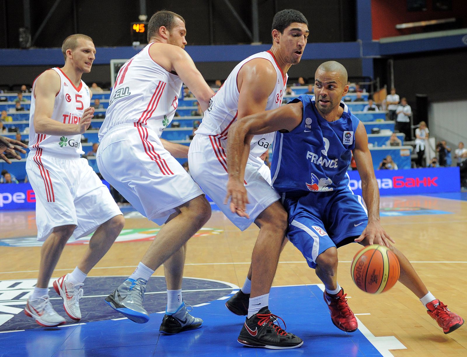 Parker trata de alcanzar la canasta ante la oposición de tres jugadores turcos, (de izq. a der.) Güler, Savas y Kunter