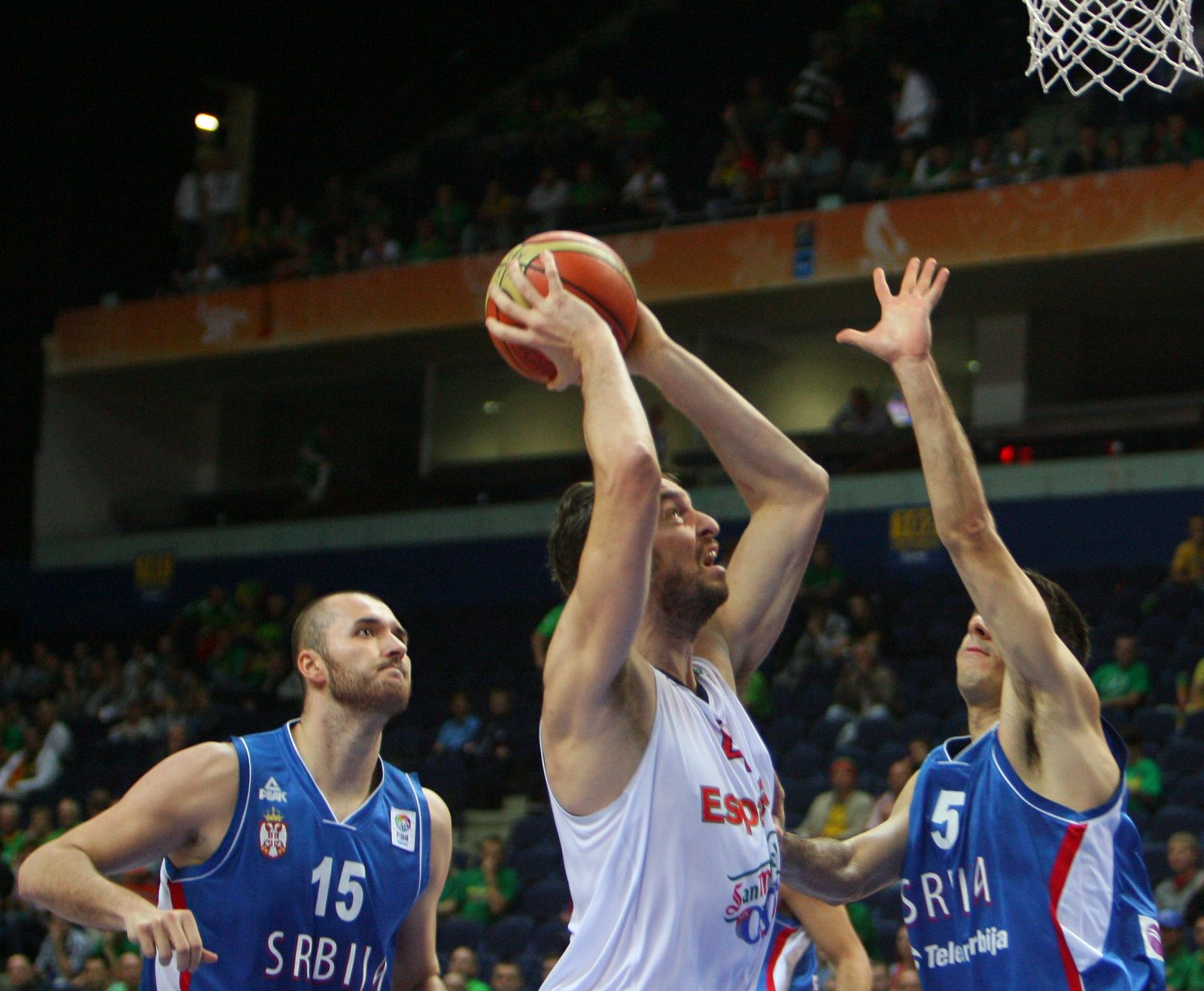 Pau Gasol penetra ante la presión de los jugadores serbios Milan Macvan (i)  y Milenko Tepic (d).