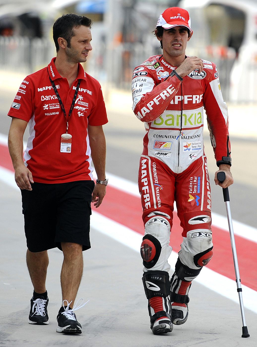 Suter Moto2 rider Simon of Spain walks with a mechanic after taking second position in qualifying session of Aragon Grand Prix in Alcaniz