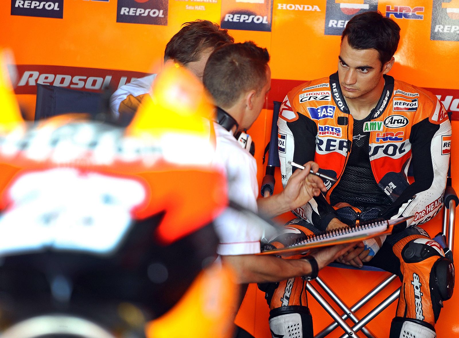 Honda MotoGP rider Dani Pedrosa of Spain listens his mechanics before the second free practice session of the Aragon Grand Prix at Motorland race track in Alcaniz
