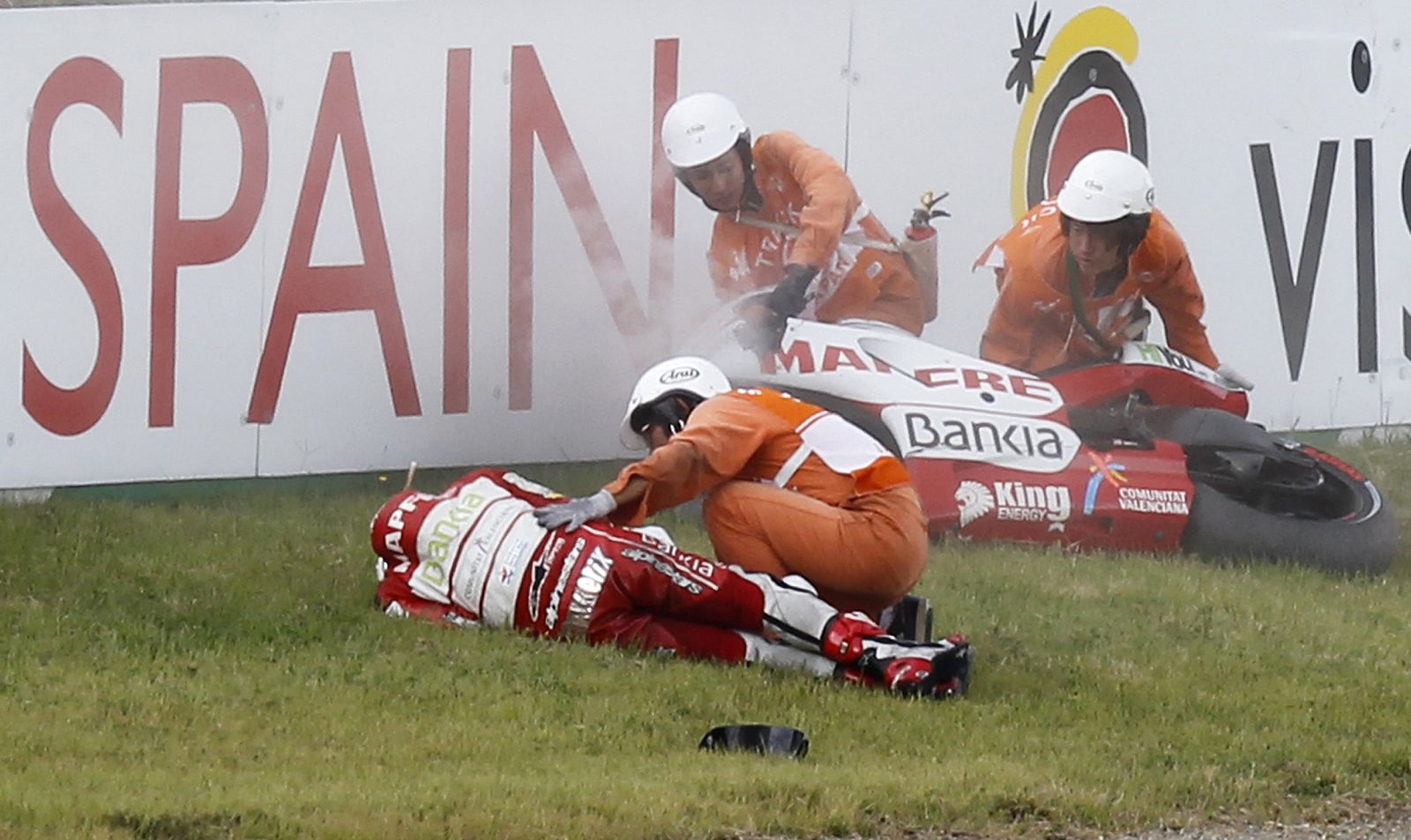 Course marshals assist Ducati MotoGP rider Barbera after he lost control of his motorcycle during the Japanese Grand Prix in Motegi