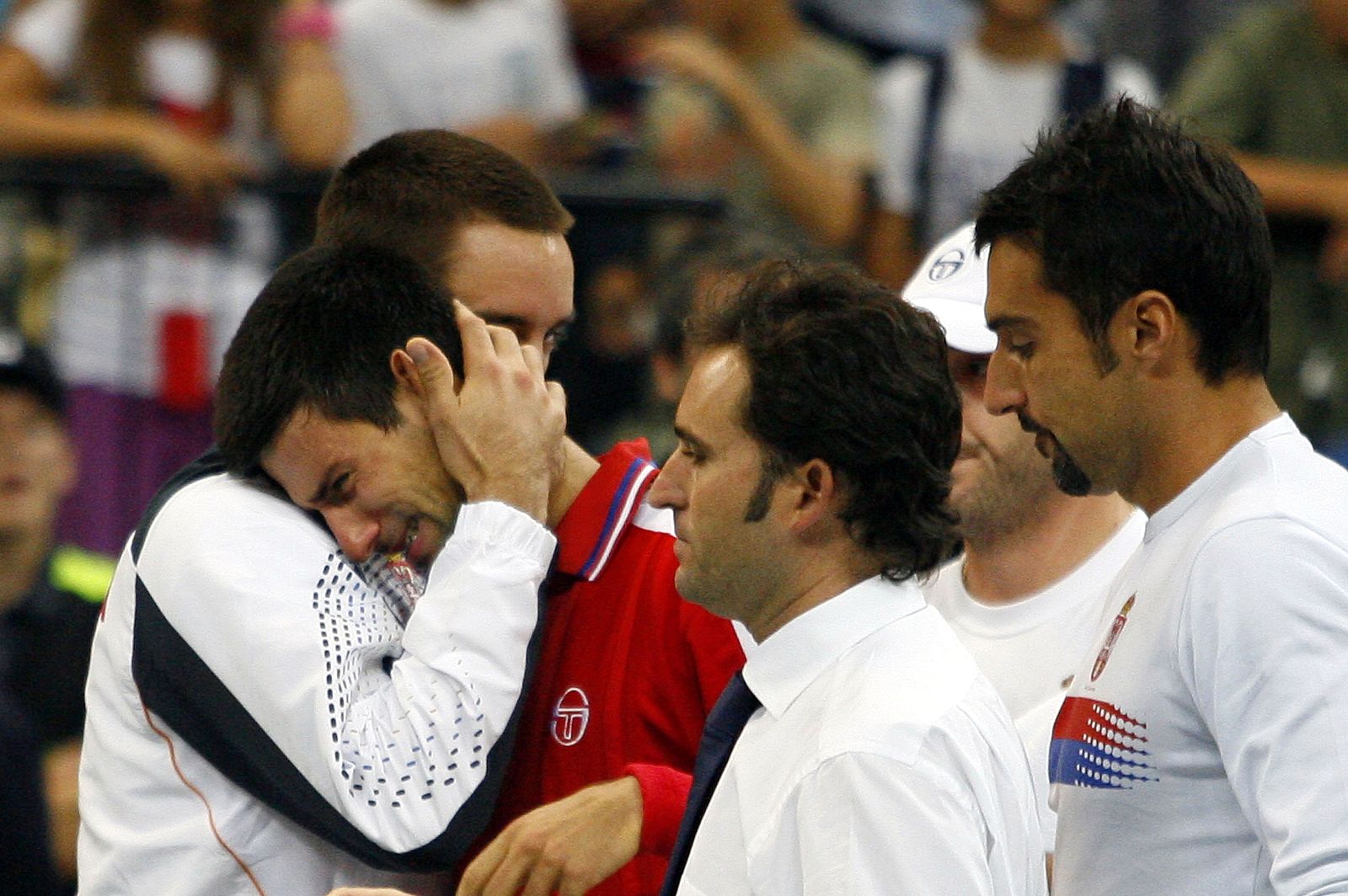 Djokovic of Serbia is comforted by team mates after his Davis Cup World Group semi-final match in Belgrade