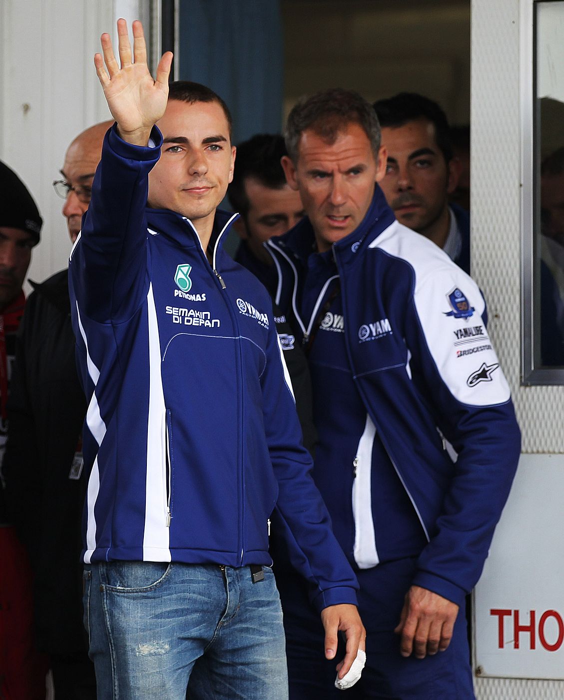 Yamaha MotoGP rider Lorenzo of Spain waves to media after being treated of his finger injury after crashing during the warm up session of the Australian Grand Prix on Phillip Island near Melbourne