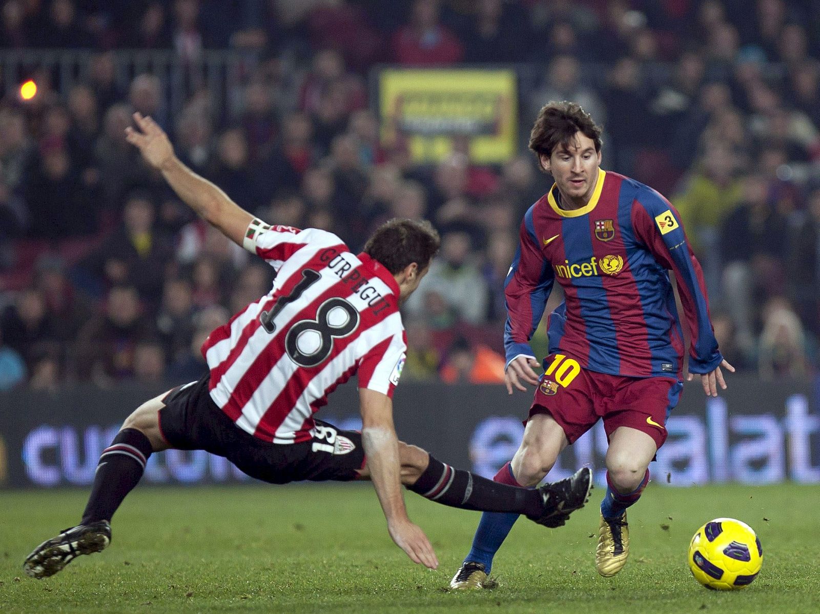 Leo Messi (d), supera la entrada del centrocampista del Ath. de Bilbao, Gurpegui, durante el encuentro.