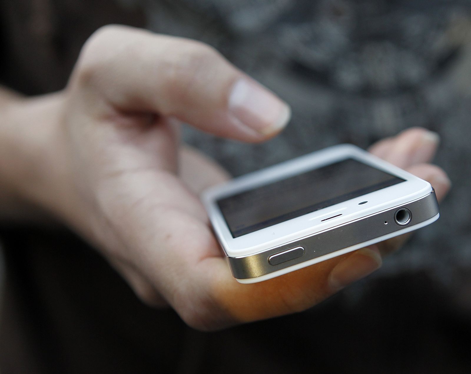 A customer uses his new iPhone 4S after making the purchase at Apple's flagship retail store in San Francisco