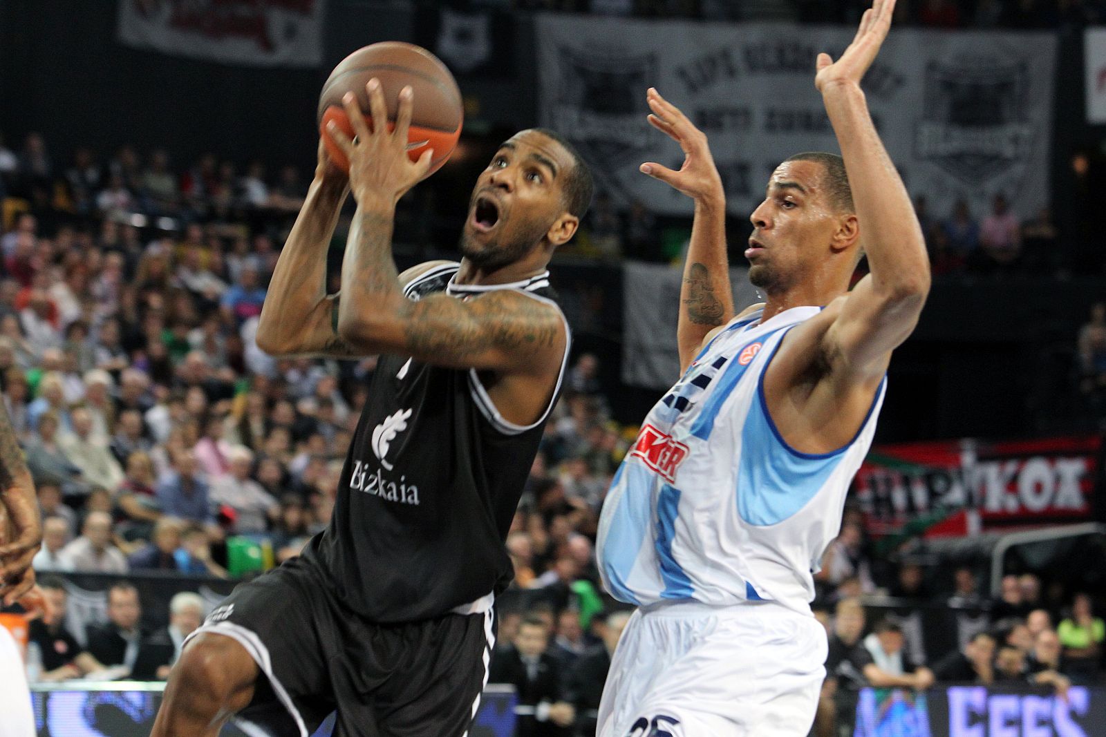 El base americano del Bizkaia Bilbao Aaron Jackson (i) entra a canasta ante el alero sueco Thabo Sefolosha.