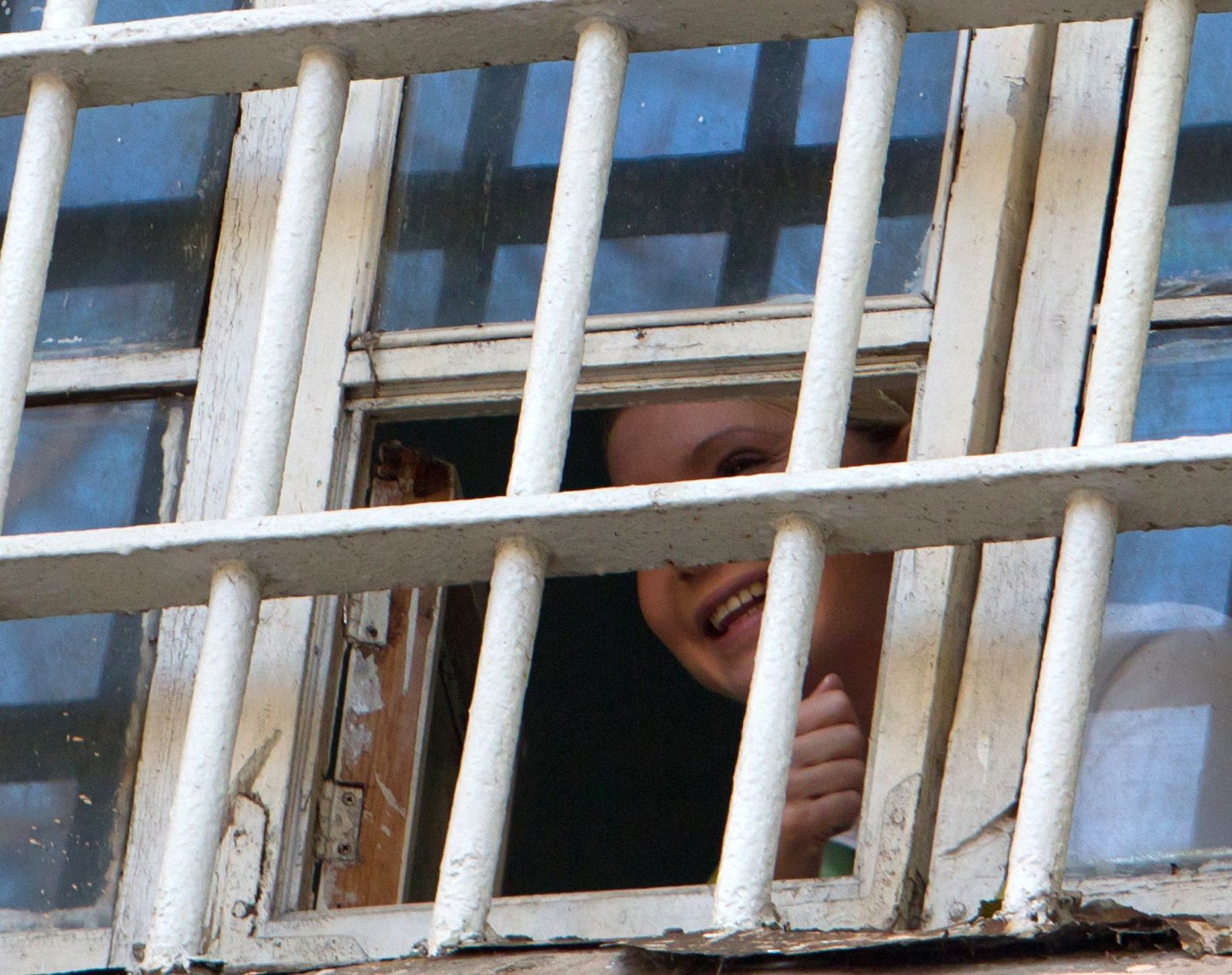 La ex primera ministra ucraniana, Yulia Tymoshenko, saluda tras las rejas de la prisión