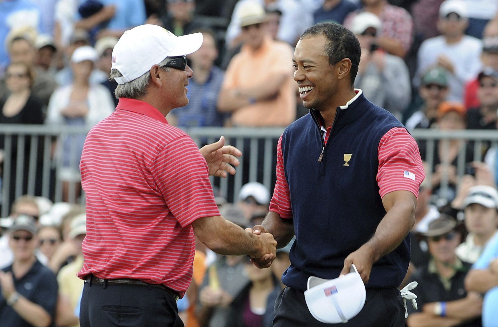 El capitán del equipo de EE.UU. Fred Couples felicita al golfista estadounidense Tiger Woods durante la última jornada de celebración de la Copa Presidentes
