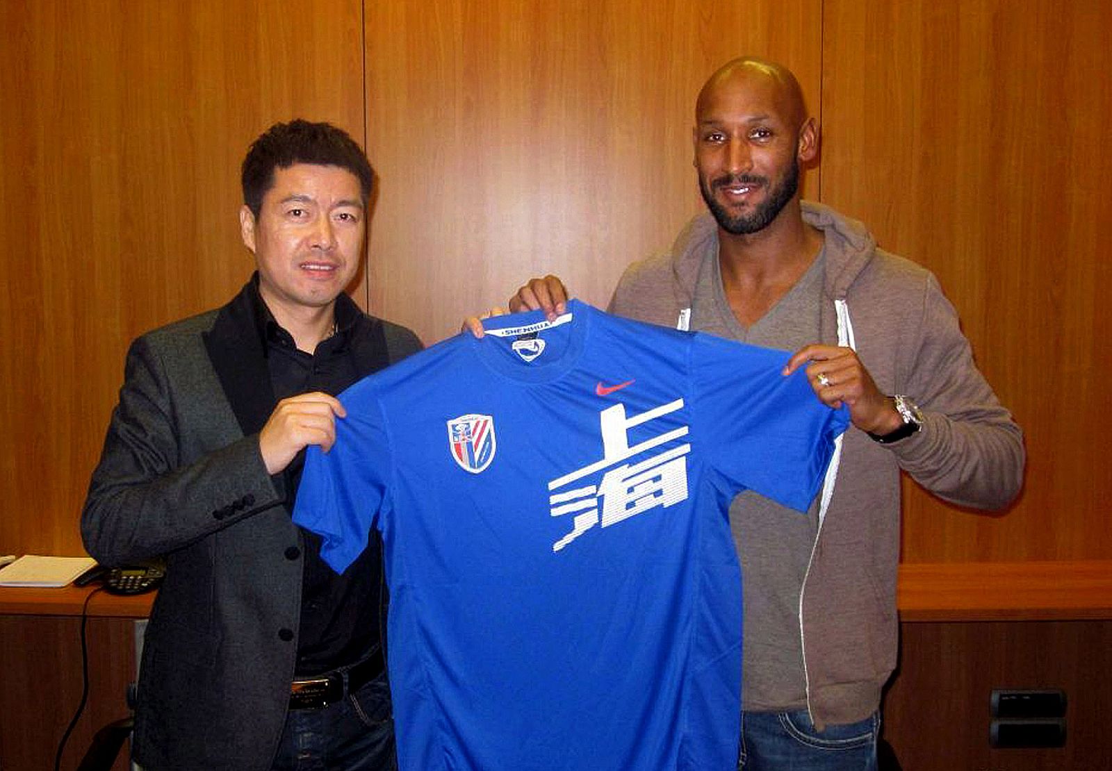 Imagen publicada por el Shanghai Shenhua que muestra a Nicolas Anelka (R) con una camiseta del club Shenhua.