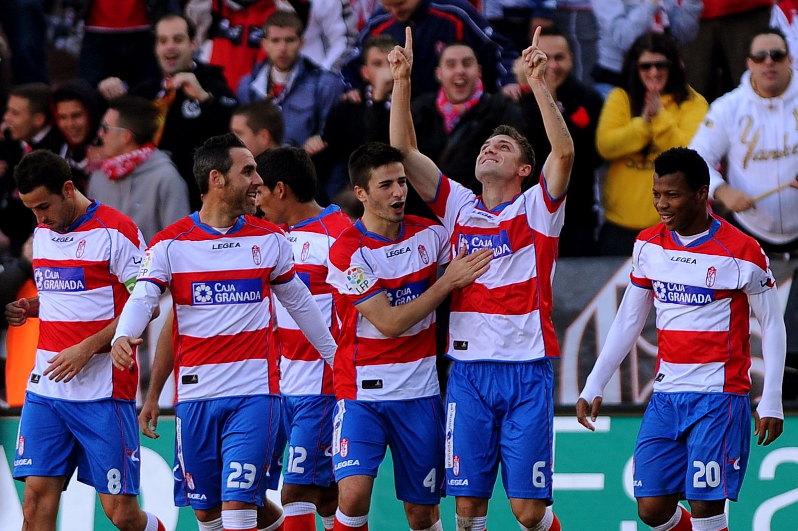 El jugador del Granada Siqueira celebra su gol mientras sus compañeros le felicitan.