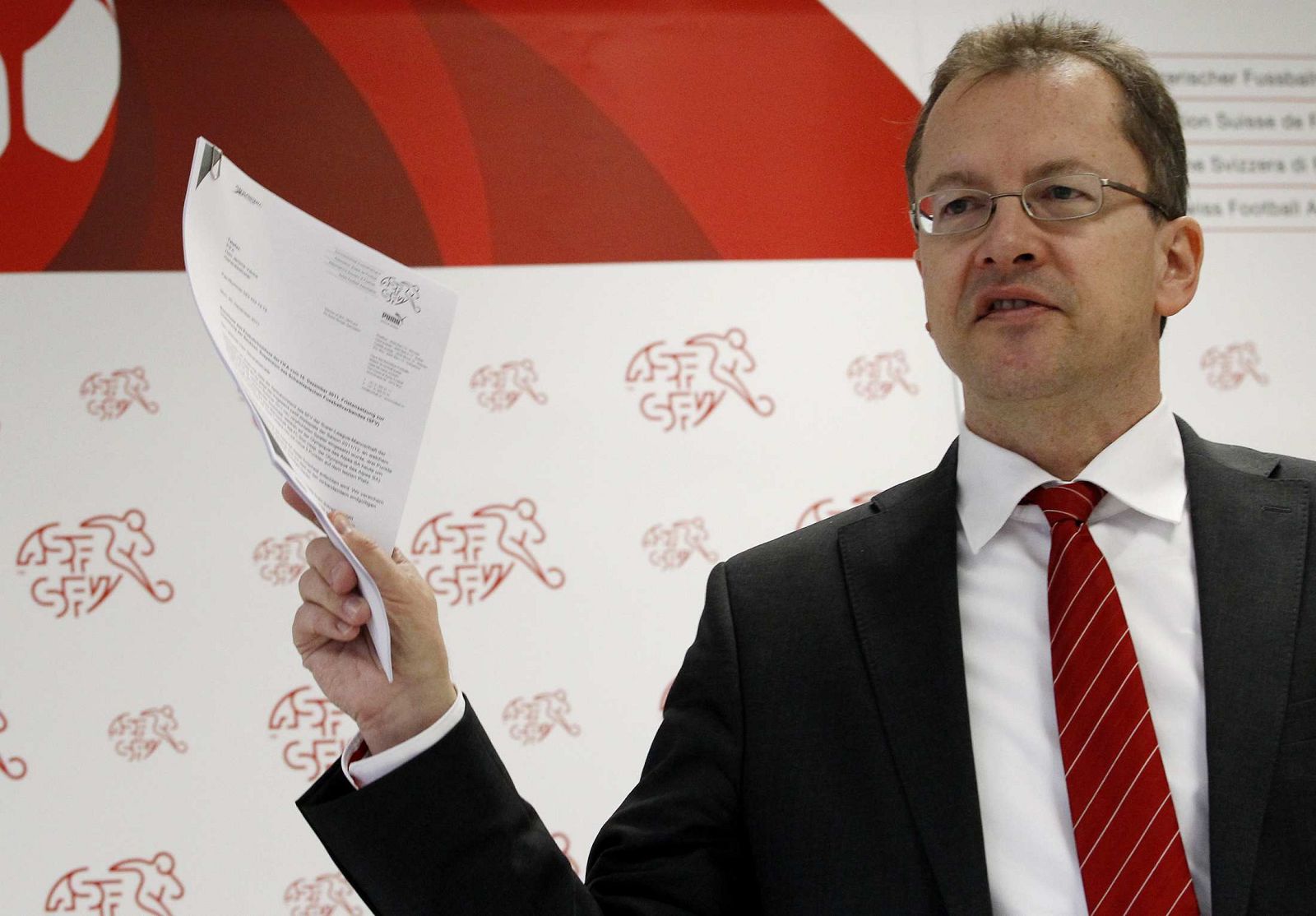 SFV spokesperson Marco Von Ah holds documents on the FC Sion during a news conference in Muri near Bern