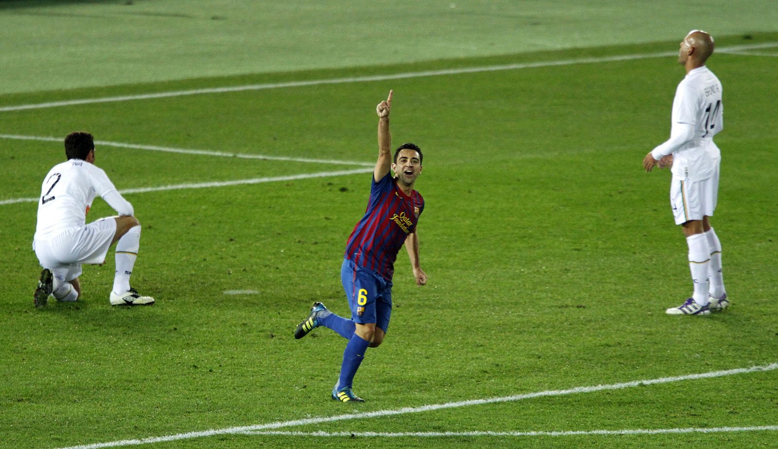 Xavi of Spain's Barcelona celebrates a goal as Dracena and Rodrigo of Brazil's Santos react during their Club World Cup final soccer match in Yokohama