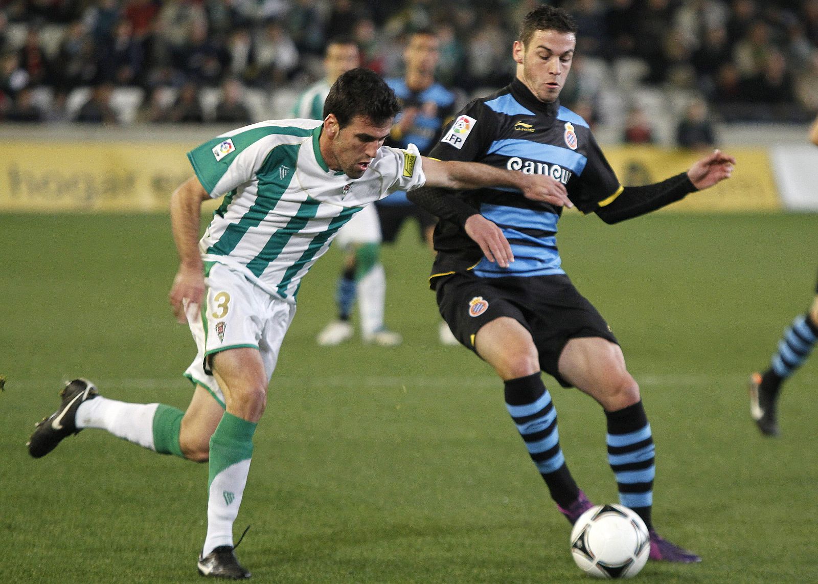 El defensa del Córdoba Juan Rafael Fuentes (i) pelea un balón con el delantero del RCD Espanyol Álvaro Vázquez.