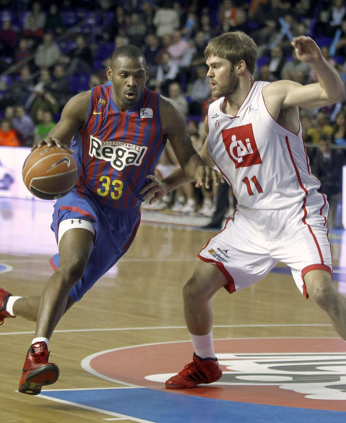 El alero estadounidense del Barcelona Regal Pete Mickeal (i), intenta superar al escolta del CAI Zaragoza, Jon Stefansson.