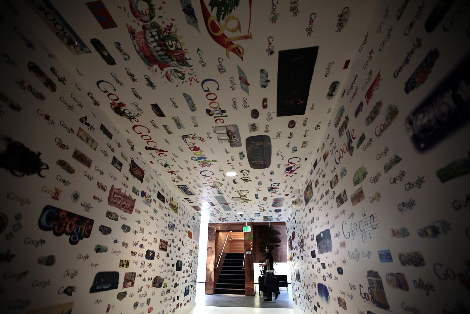 File photo of a woman walking past a tunnel of Google homepage logos at the Google campus in Los Angeles