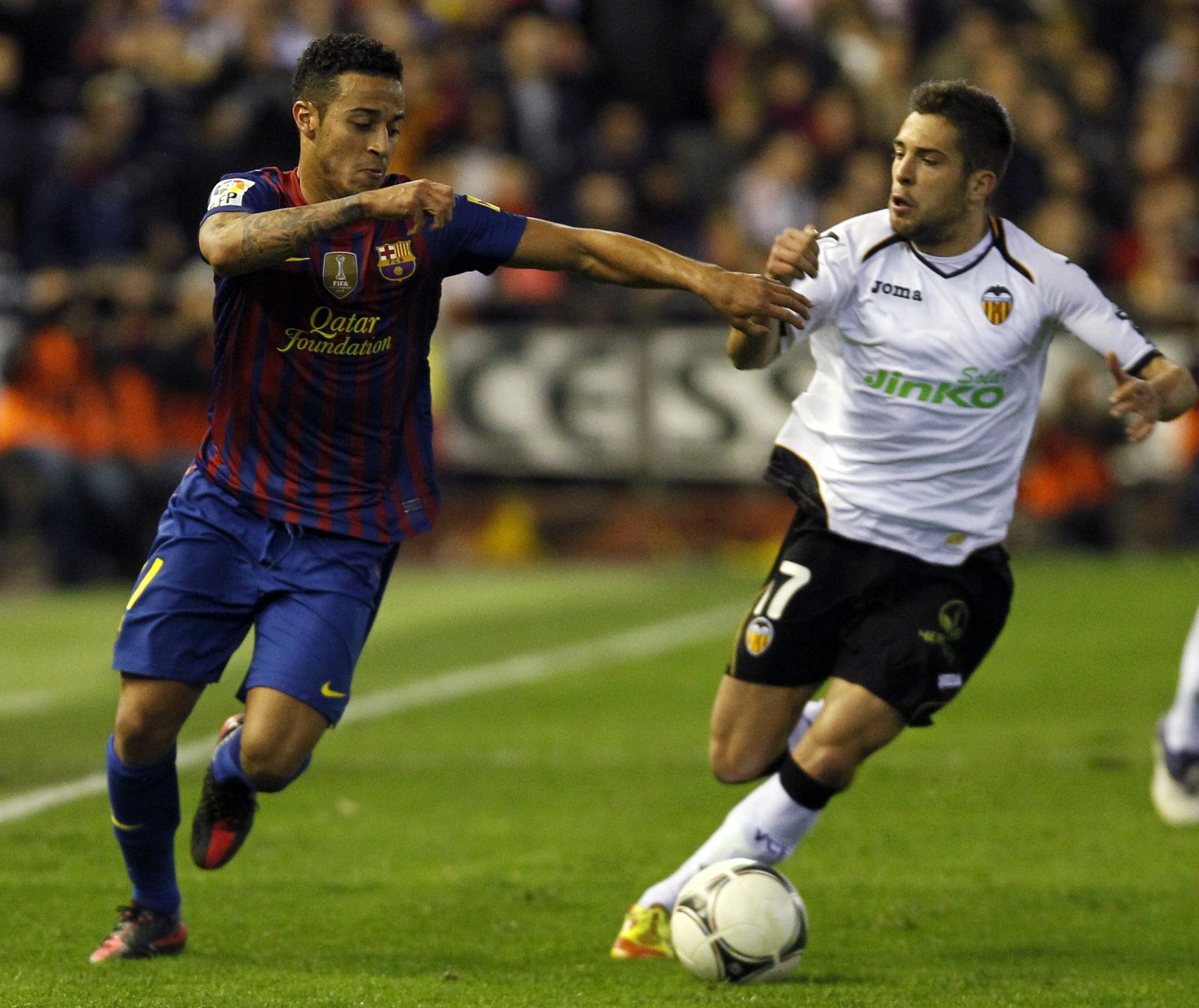 Barcelona's Thiago fights for the ball with Valencia's Alba during their Spanish King's Cup semi-final soccer match in Valencia
