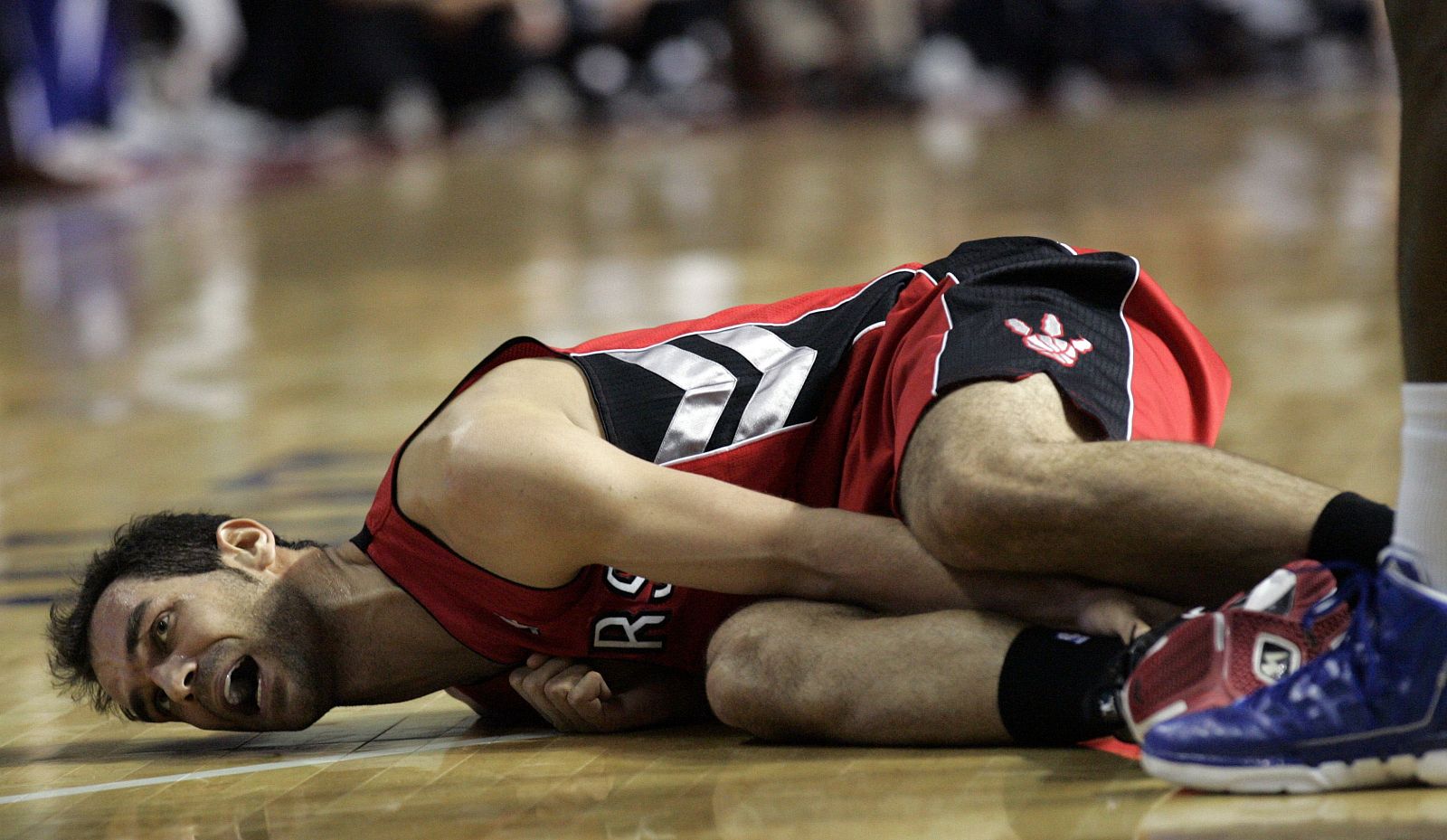 Toronto Raptors Jose Calderon lies on the court in pain during their NBA basketball game against the Detroit Pistons in Auburn Hills
