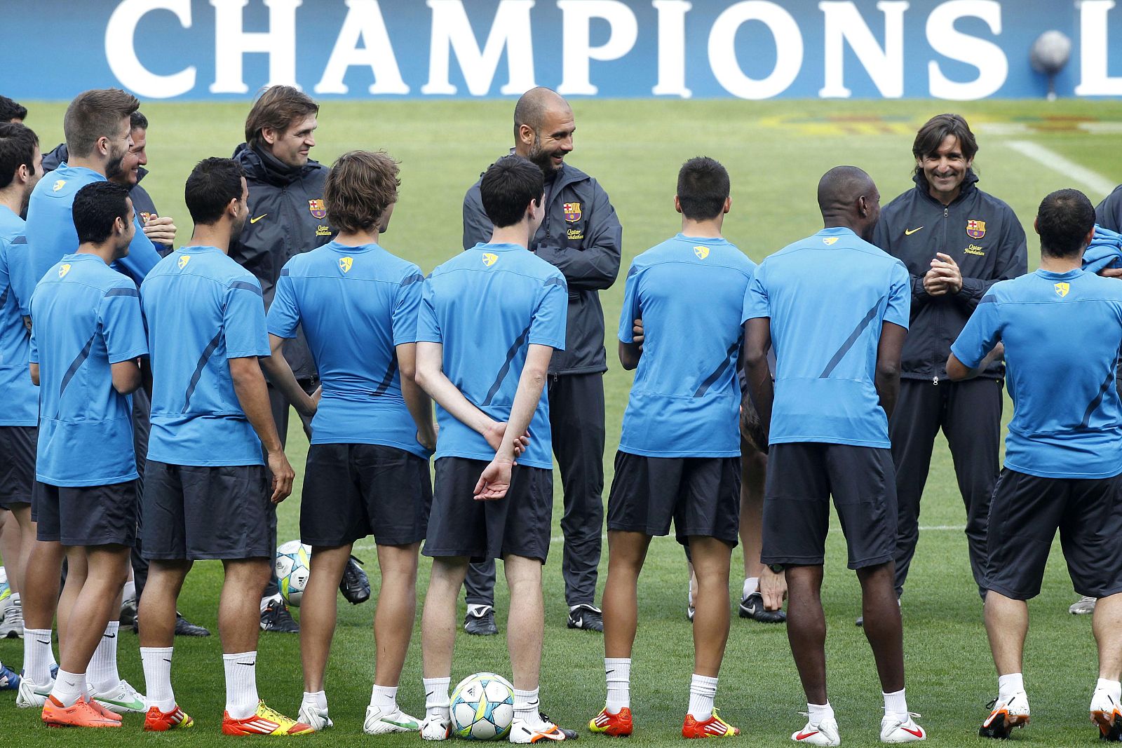 Barcelona's coach Pep Guardiola and his players smile during a training session at Nou Camp stadium in Barcelona