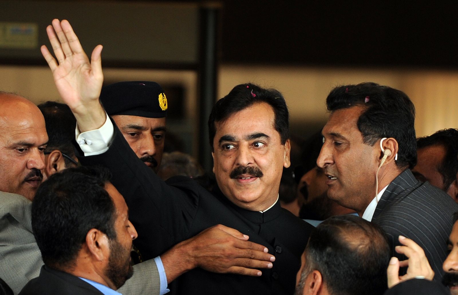 El primer ministro de Pakistán, Yusuf Raza Guilani, en el centro, escultado a su llegada al Supremo el 26 de abril