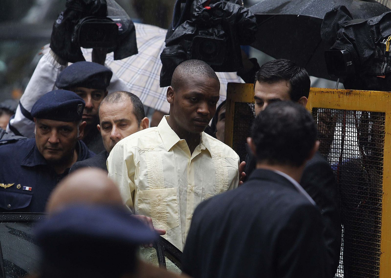 El joven Johnny Jean, escoltado por la policía, llega a la corte de Justicia de Montevideo ante la expectación de la prensa
