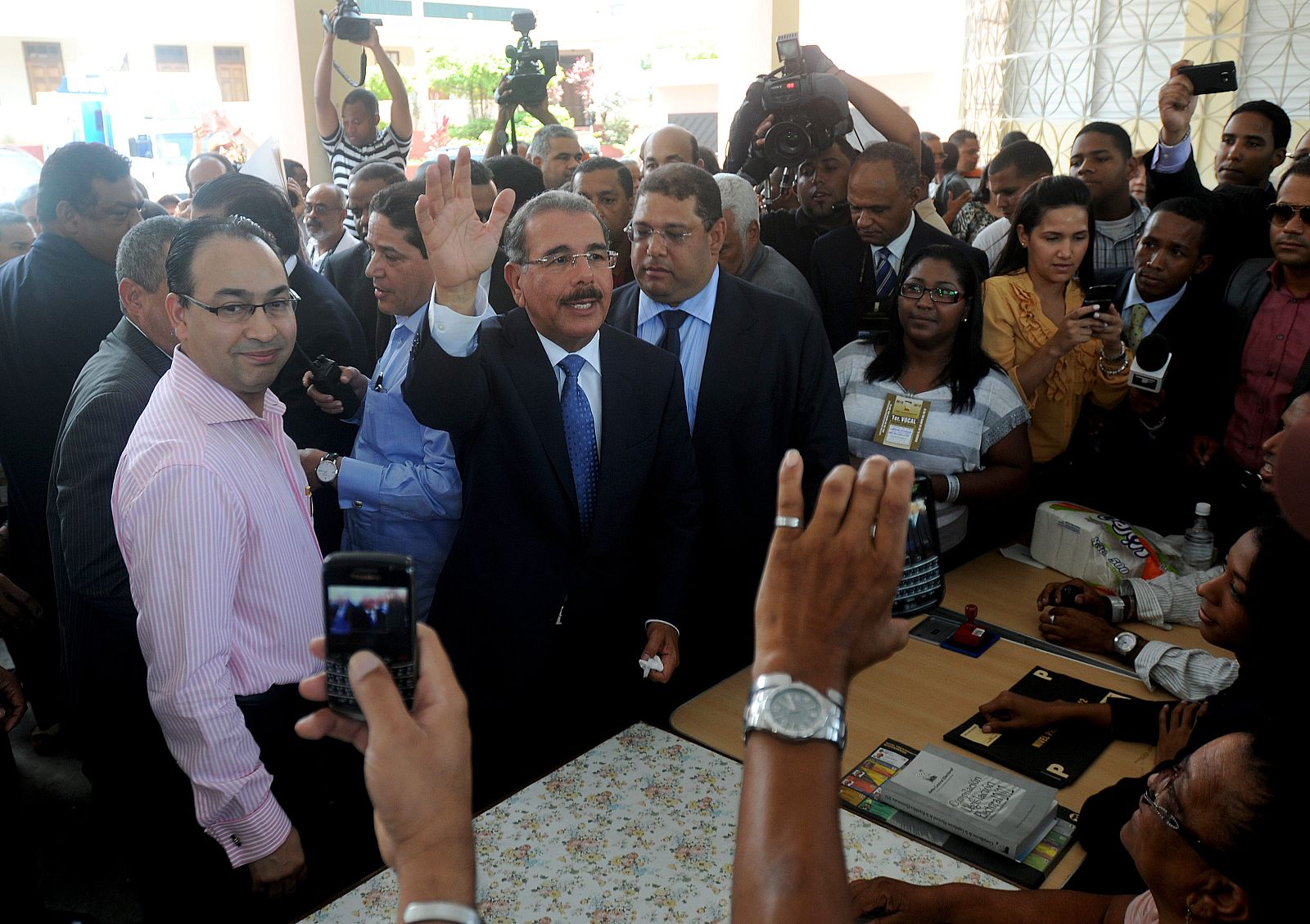 Danilo Medina (c), candidato presidencial del oficialista Partido de la Liberación Dominicana (PRLD), saluda tras depositar su voto durante las elecciones presidenciales de este domingo 20 de mayo de 2012