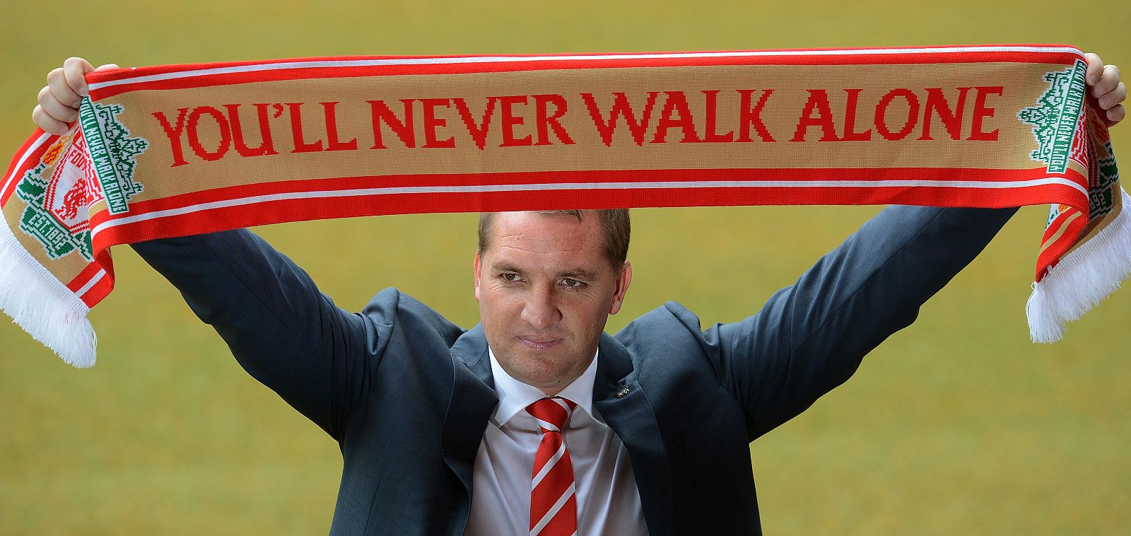 El entrenador Brendan Rodgers posa con la bufanda del Liverpool, su nuevo equipo.