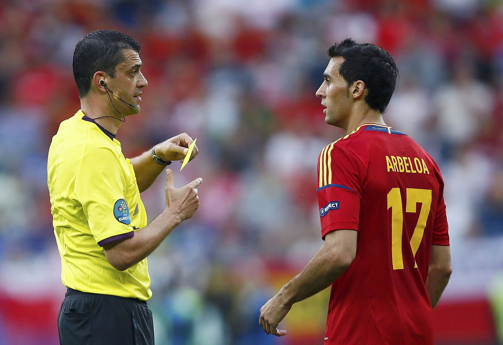 El colegiado del partido ante Italia, Viktor Kassai, muestra tarjeta amarilla a Alvaro Arbeloa.