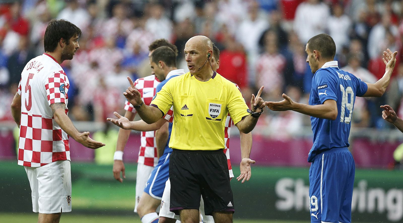 El árbitro inglés Howard Webb media entre los jugadores durante el partido.