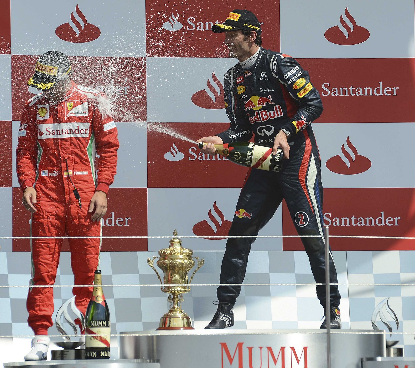 Red Bull Formula One driver Mark Weber of Australia (R) sprays  Ferrari Formula One driver Fernando Alonso after winning the British F1 Grand Prix at Silverstone, central England