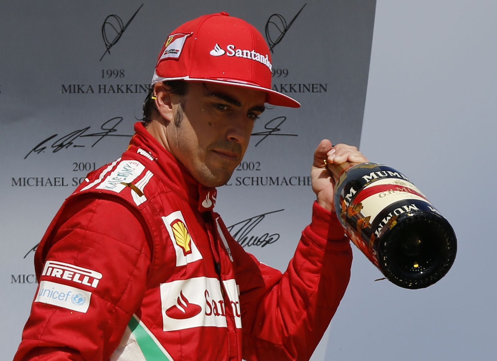 Ferrari Formula One driver Alonso of Spain holds a bottle of champagne after winning the German F1 Grand Prix at the Hockenheimring
