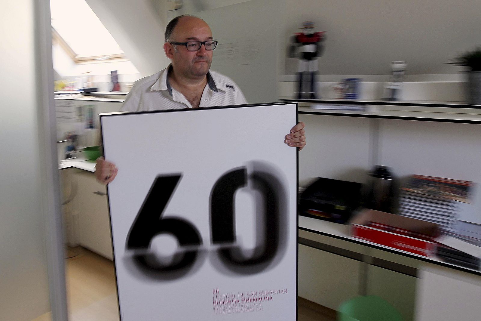 El director del Festival de Cine de San Sebastián, José Luis Rebordinos, con el cartel de la 60 edición del certamen