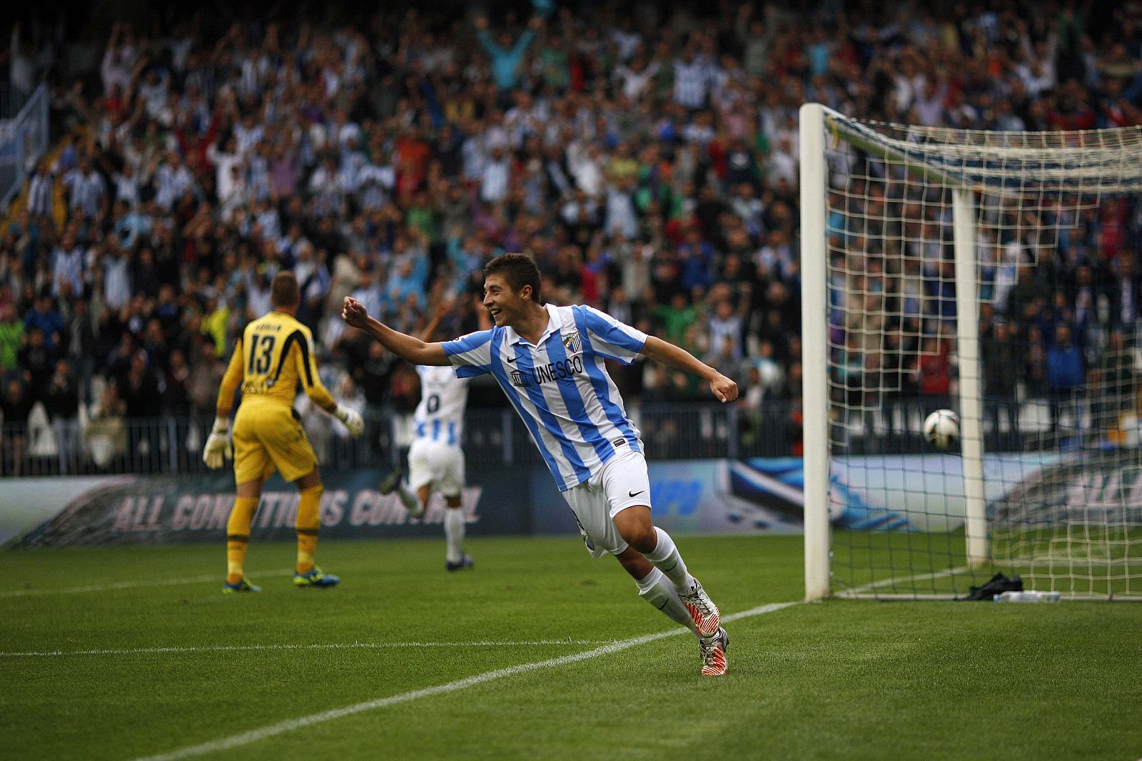 El jugador del Málaga Francisco Portillo celebra el gol de su compañero Javier Saviola .