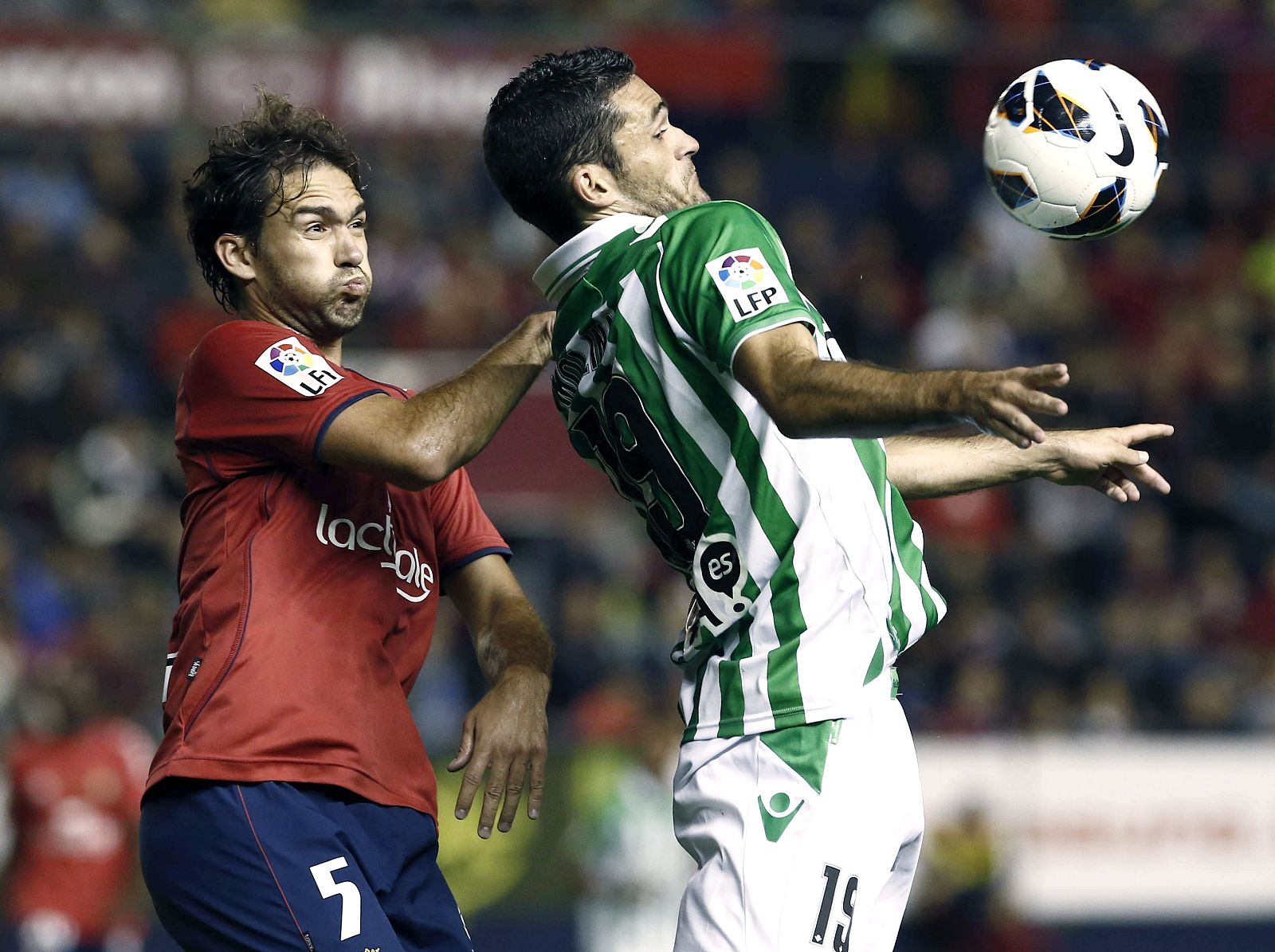 El defensa de Osasuna Lolo Ortiz lucha la pelota con el delantero del Betis Jorge Molina.