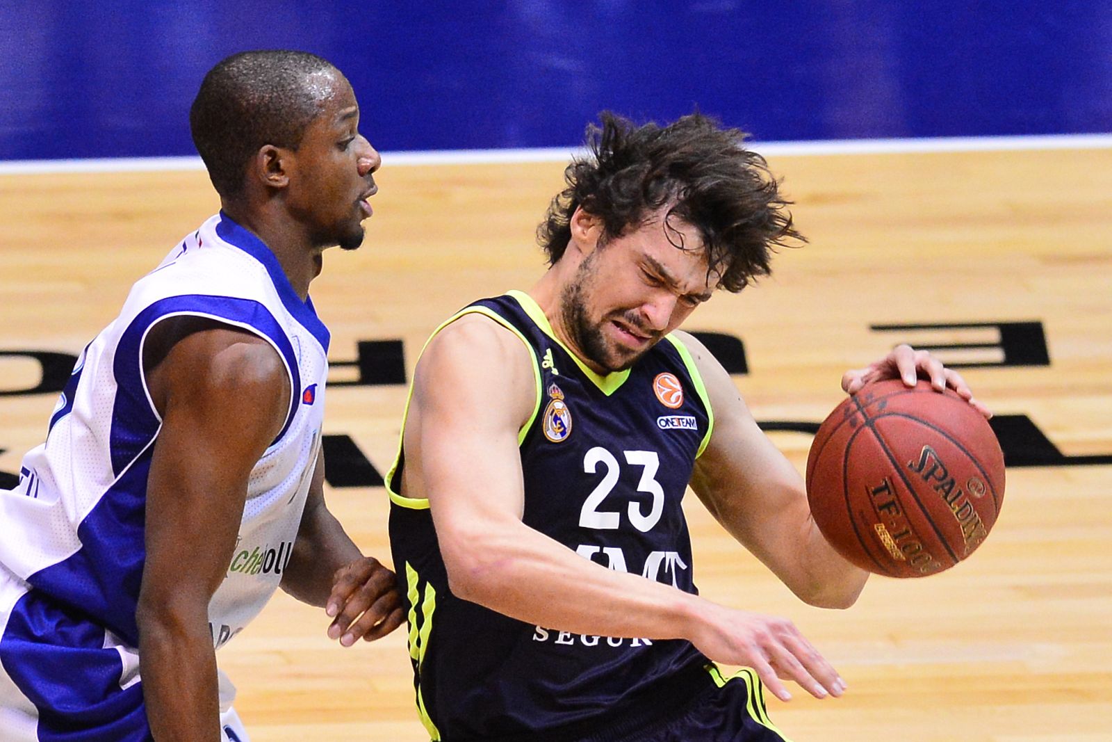 El jugador del Cantù Jonathan Tabu obstaculiza el avance de Sergio Llull.