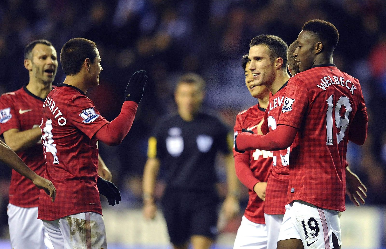 Robin Van Persie (2i) celebra con su compañeros Javier 'Chicharito' Hernandez (2I) su tanto ante el Wigan.