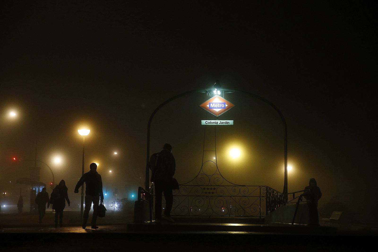 Varias personas acceden al metro a primera hora de este jueves, entre la intensa niebla.