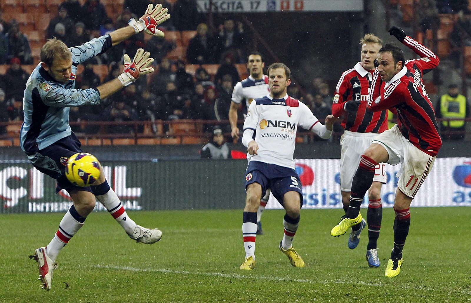 AC Milan's Pazzini shoots to score a second goal past Bologna's Agliardi during their Italian Serie A soccer match at the San Siro stadium in Milan