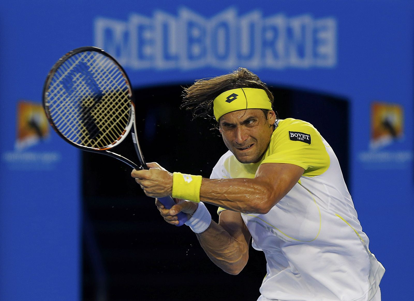 David Ferrer of Spain hits a return to Novak Djokovic of Serbia during their men's singles semi-final match at the Australian Open tennis tournament in Melbourne