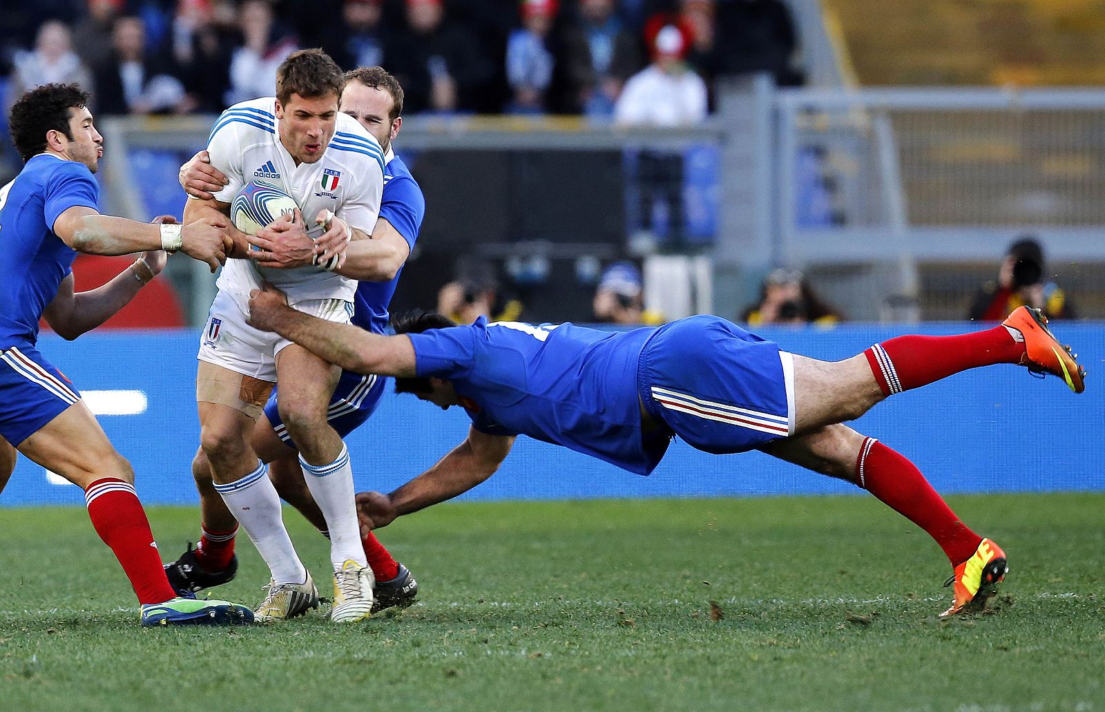 Italy's Benvenuti is tackled by Fritz and Michalak of France during their Six Nations international Rugby Union match at the Olympic stadium in Rome