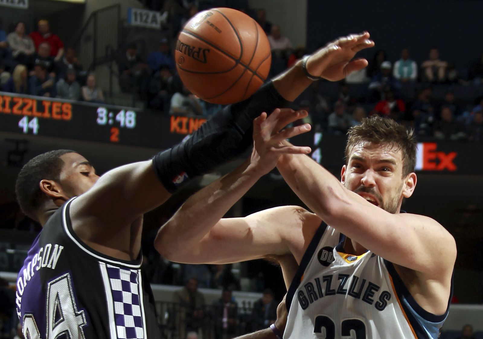 Marc Gasol (d) de los Grizzlies recibe una falta de Thompson de los Kings