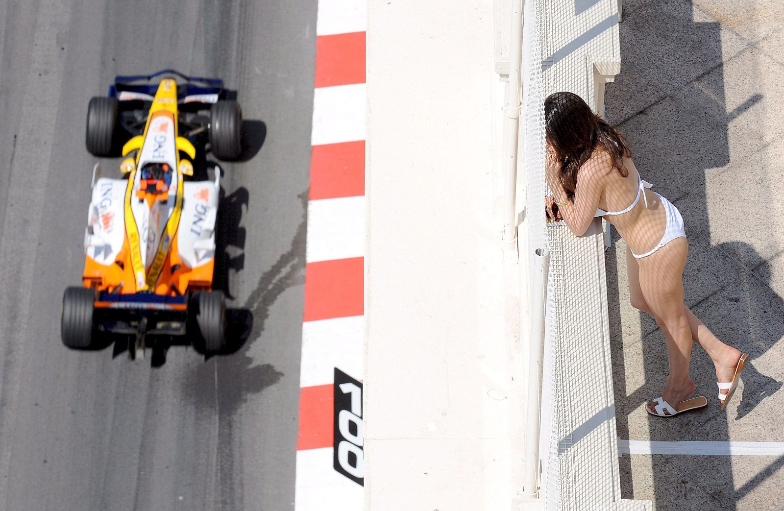 Una mujer en traje de baño observa el Fórmula Uno de Fernando Alonso en Mónaco
