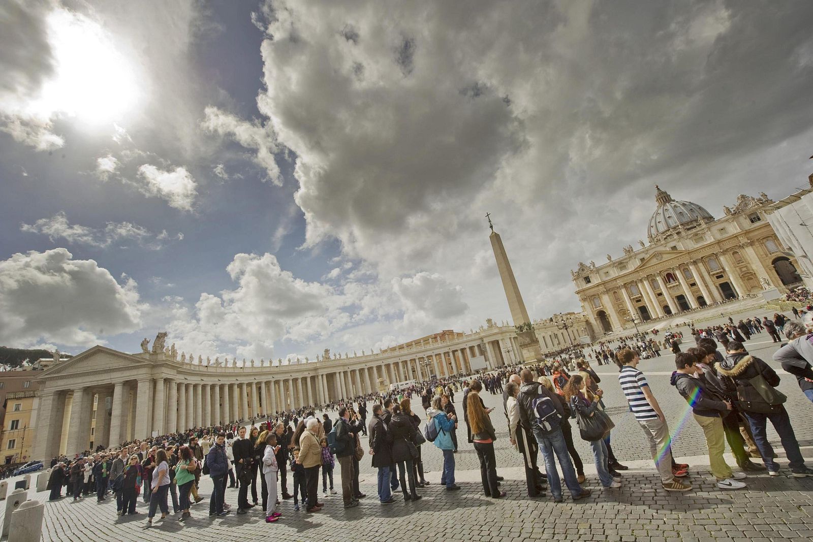 Varios visitantes permanecen en la plaza de San Pedro, en Ciudad del Vaticano, este 11 de marzo.