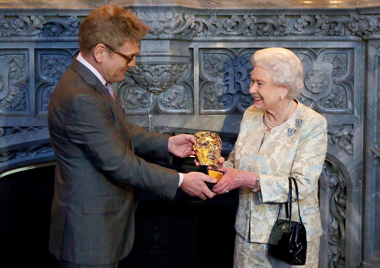 La reina Isabel II recibe el Bafta honorífico de manos del director Kenneth Branagh.