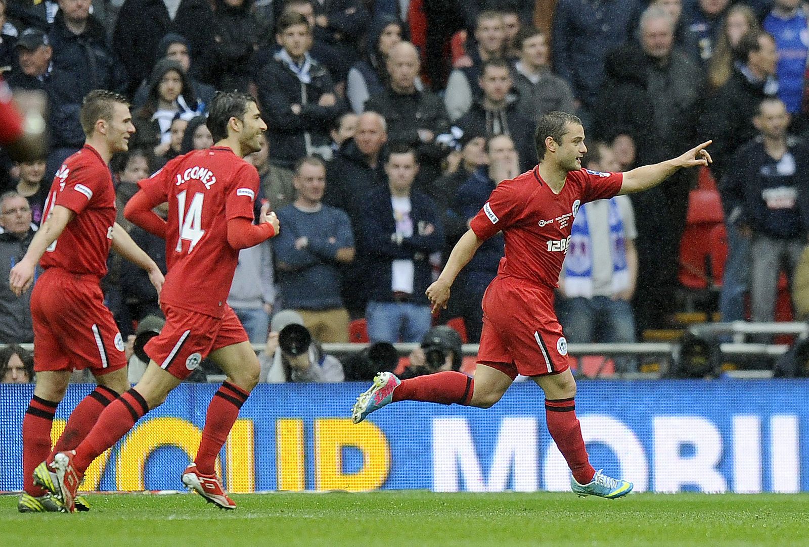 Shaun Maloney celebra el primer gol del Wigan, seguido de Jordi Gómez