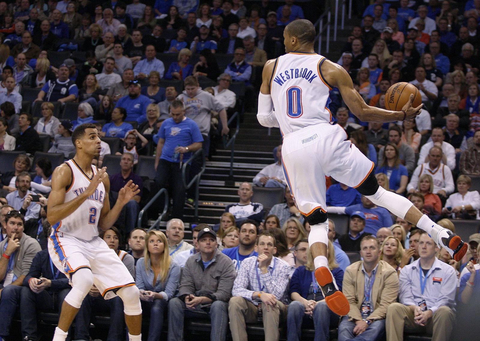 Oklahoma City Thunder guard Thabo Sefolosha of Switzerland watches as Thunder guard Russell Westbrook leaps to save a ball from going out of bounds against San Antonio Spurs in the first half of their NBA basketball game in Oklahoma City.